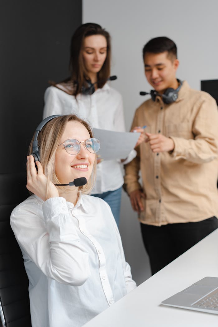 Group of call center operators in an office setting collaborating and using headsets.